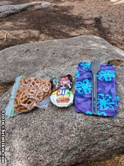 Photo of pretzels, peanut butter, and candy on a rock