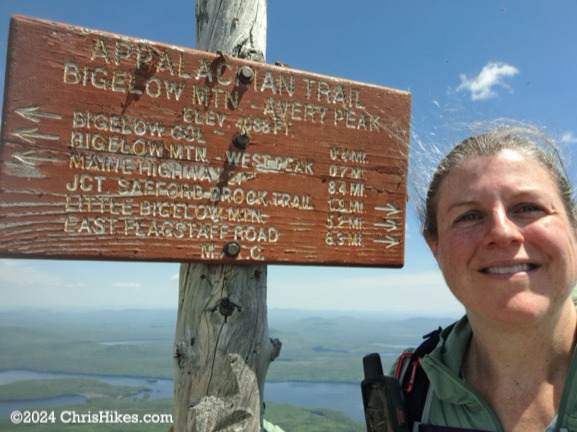 Chris standing next to Avery summit sign