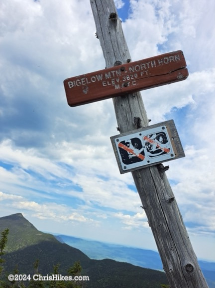 North Horn summit sign on a post leaning to the left along with signs for no camping and no fires