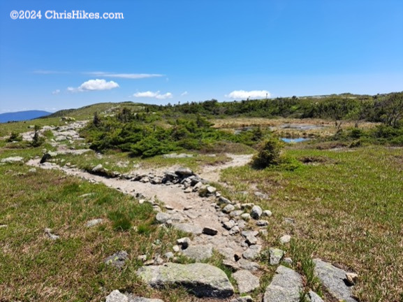 Photograph of small pond near top of a mountain.