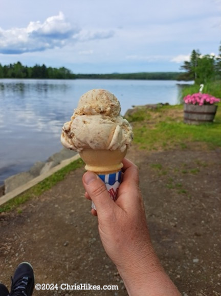 Photograph of ice cream cone with lake in background