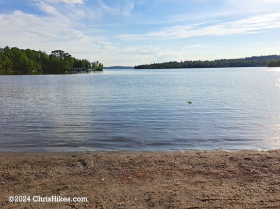 Photograph of beach leading into lake