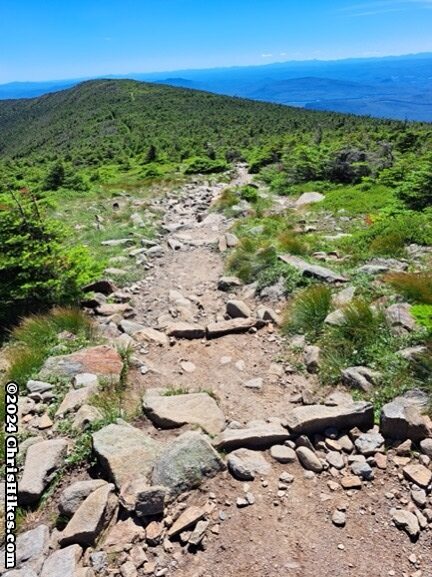 photograph of hiking trail on summit ridge with some rocks in the trail